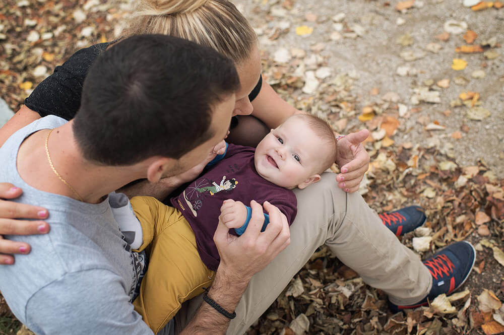 Portrait de bébé souriant sur les genoux de papa.