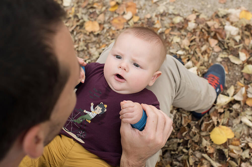 Portrait de bébé inquiet sur les genoux de papa.