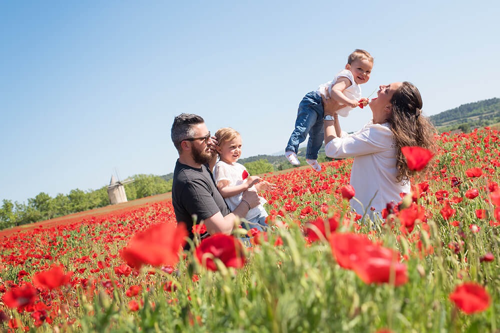 Séance photo famille dans un champ de coquelicots.