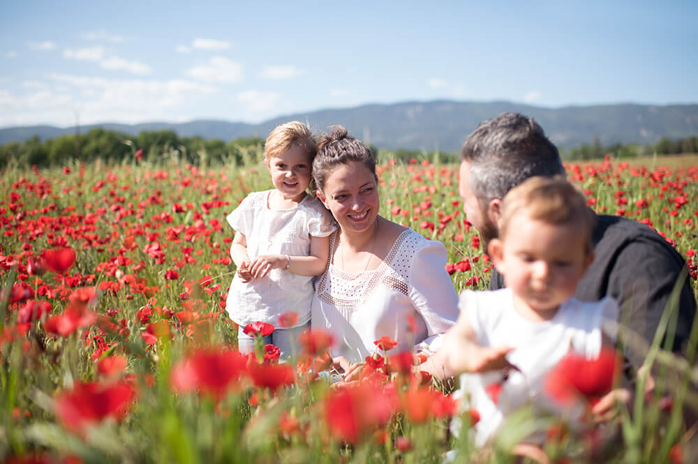 Séance photo famille dans un champ de coquelicots.