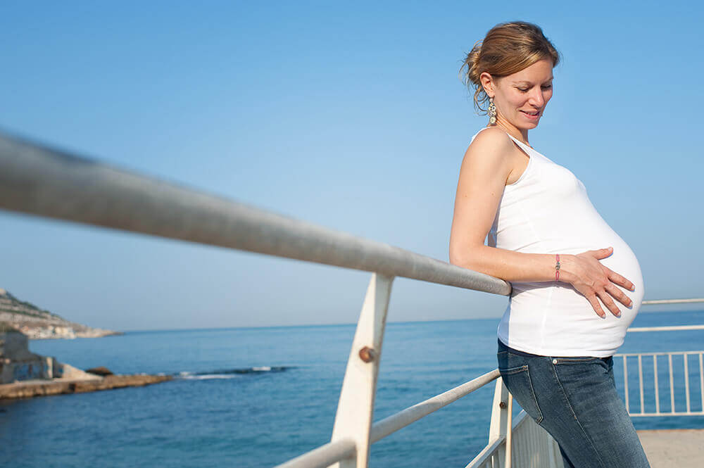 Femme enceinte devant la mer.