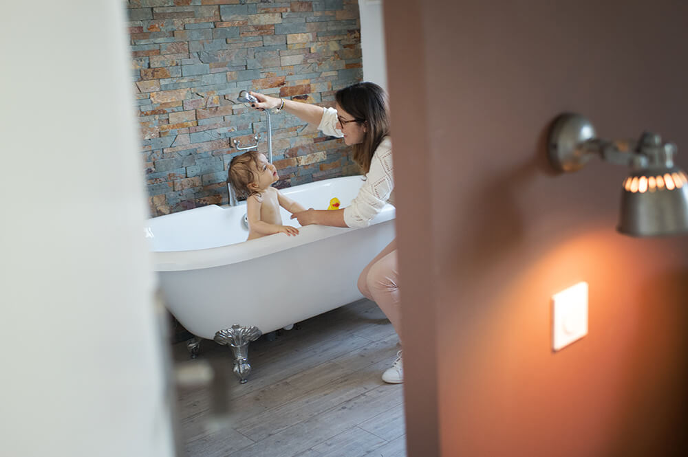 Maman qui douche son enfant.