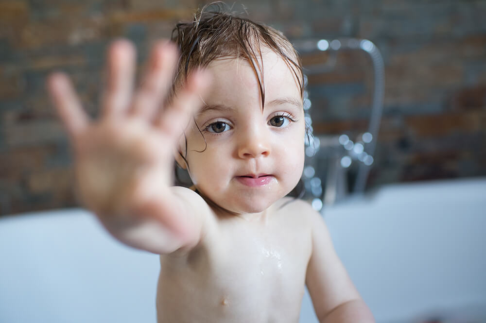 Bébé mouillé dans le bain. Jeu d'eau.