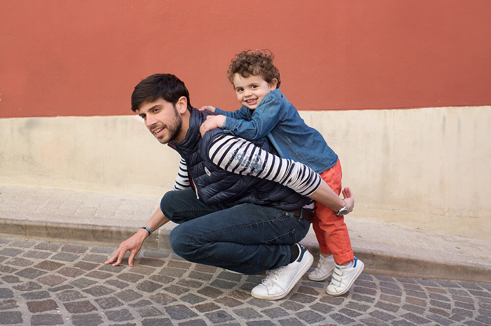 Portrait d'enfant et son père dans une ruelle en pavés.