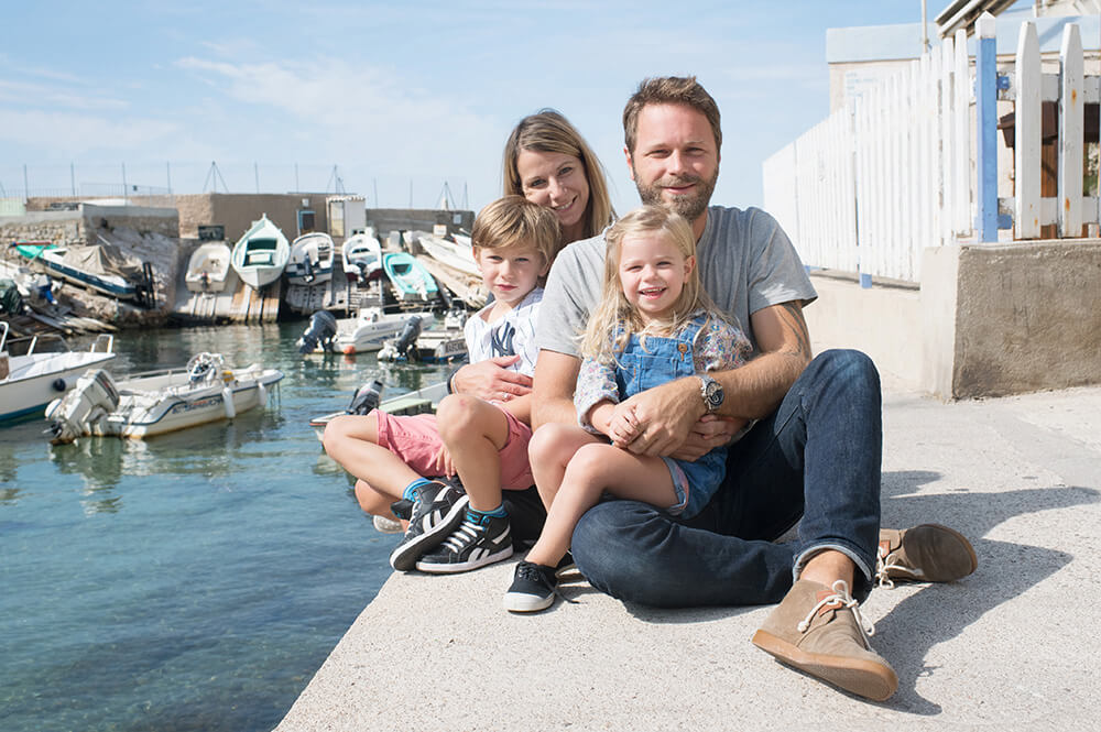 Photo de famille assise au bord de l'eau