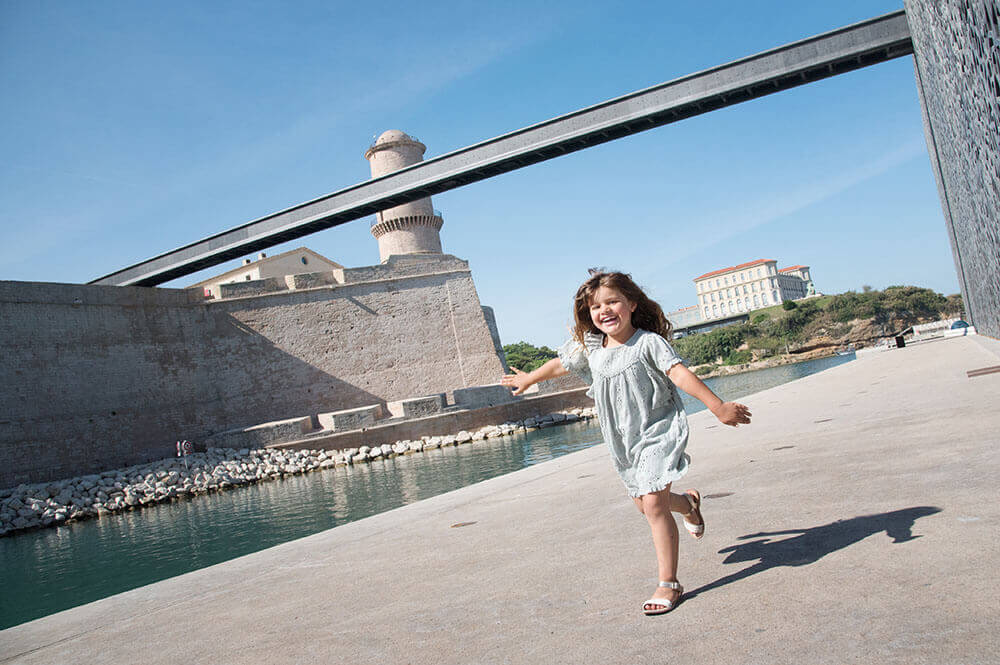 Portrait d'une enfant entrain de courir devant le MuCem.