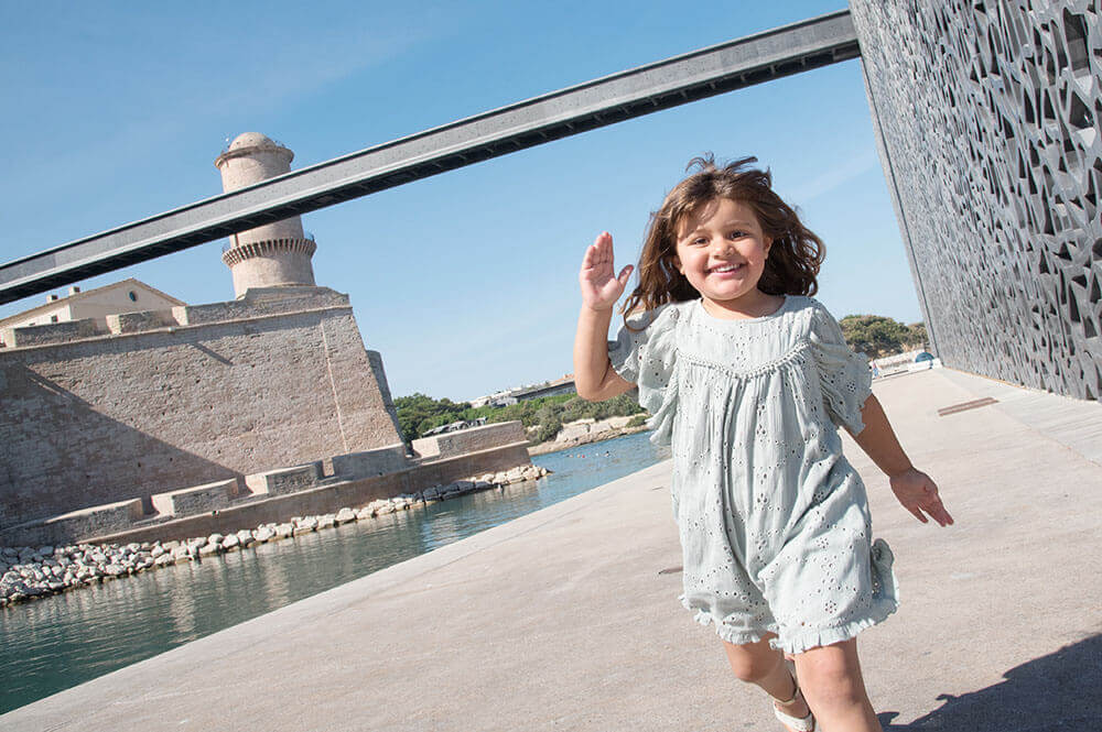 Photo d'une jeune fille entrain de courir sur la parvis du MuCem.