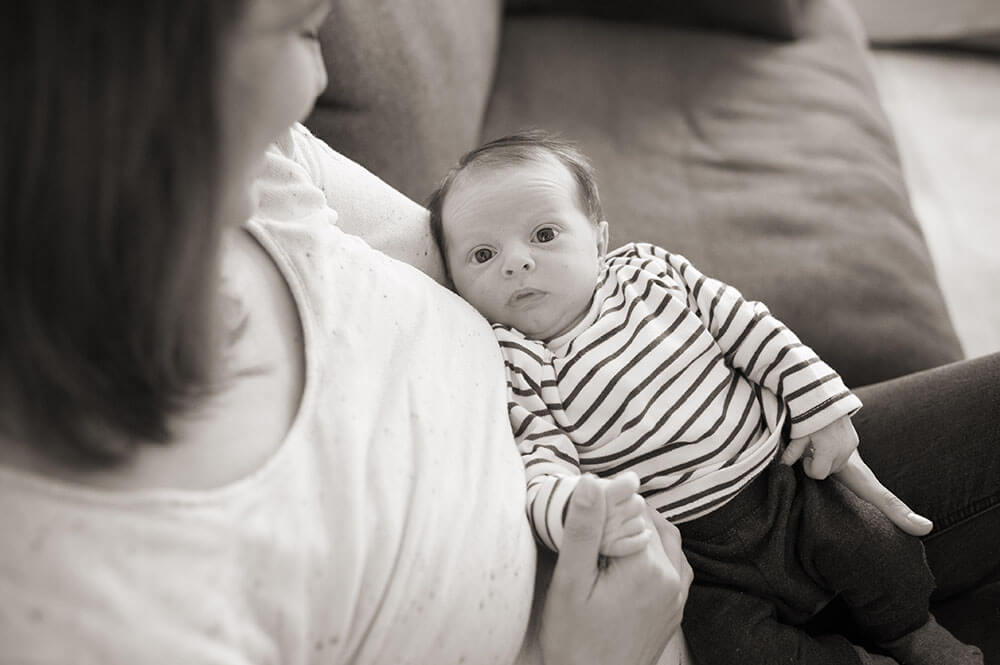 Photo nourrisson avec sa maman. Portrait en noir et blanc sur le canapé de la maison.