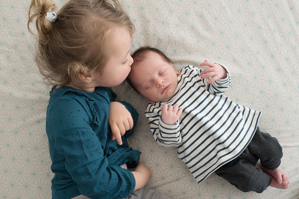 Bisous sur le front de son tout-petit frère.