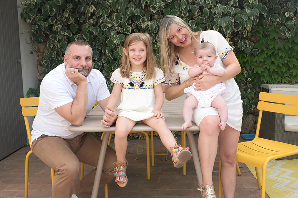 Portrait de famille assis sur une table de jardin.