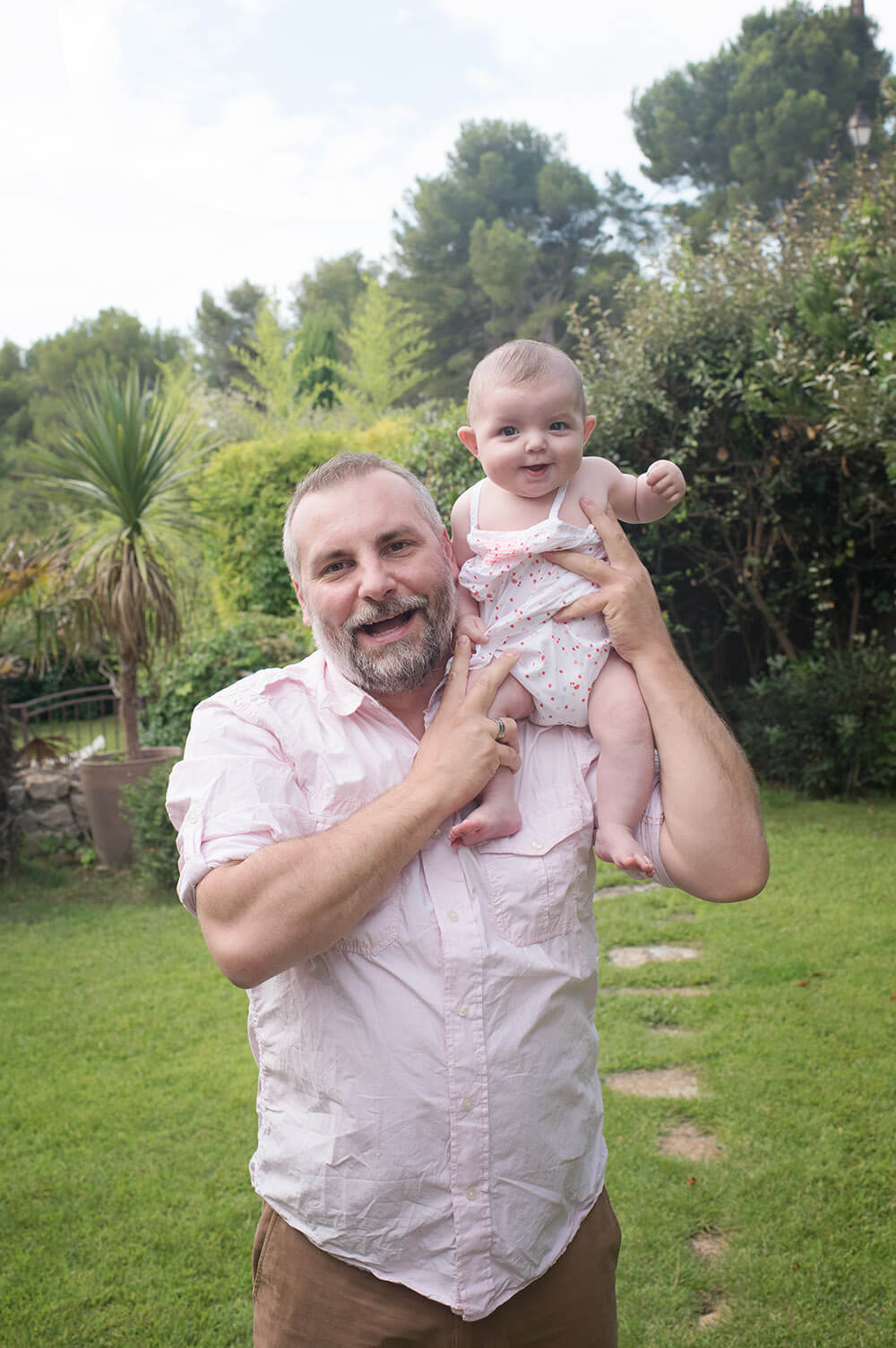 Petit bébé assis sur l'épaule de papa.