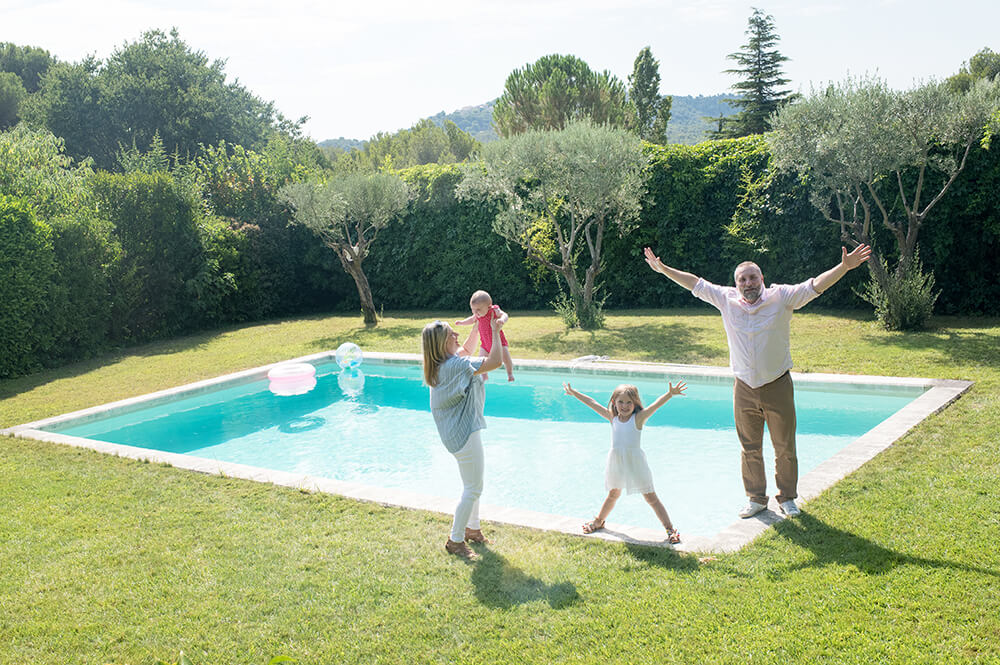 Séance photo famille à domicile à Ventabren. Portrait de famille au bord de la piscine.