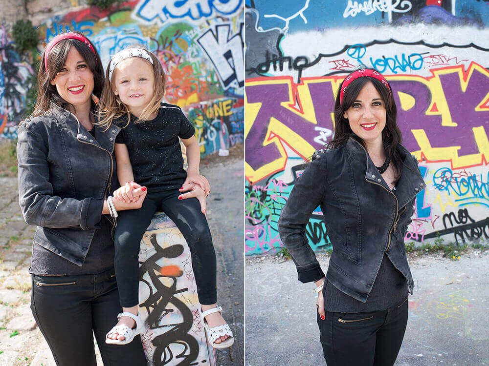 Portrait d'une enfant sur un muret devant un mur de graffitis.