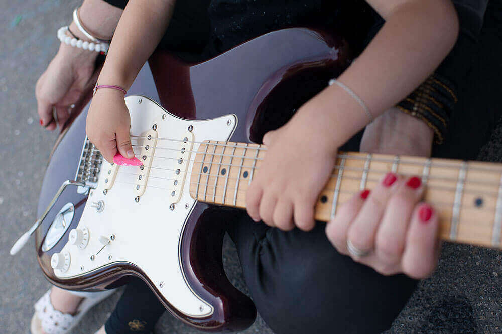 Enfant entrain de jouer de la guitare électrique.