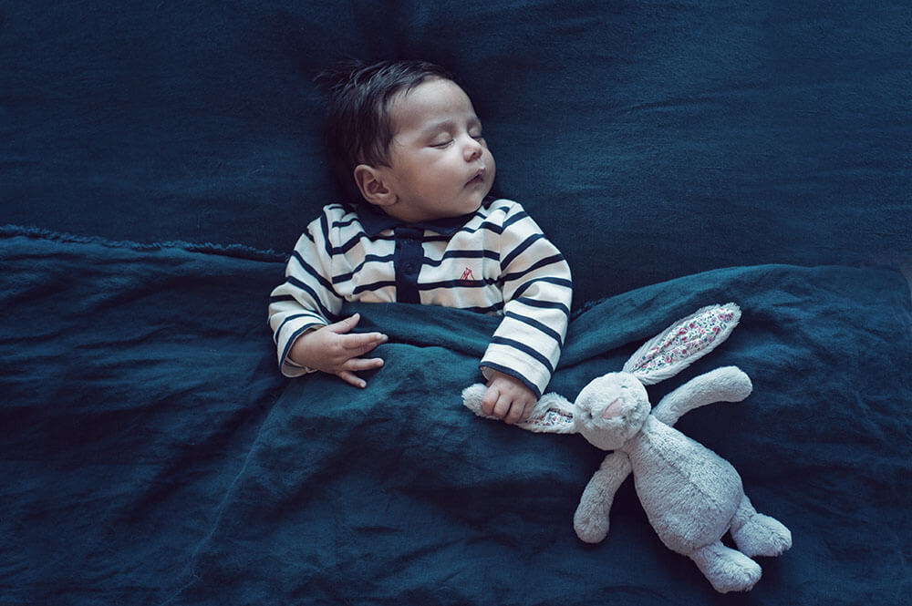 Nouveau-né entrain de dormir avec son doudou