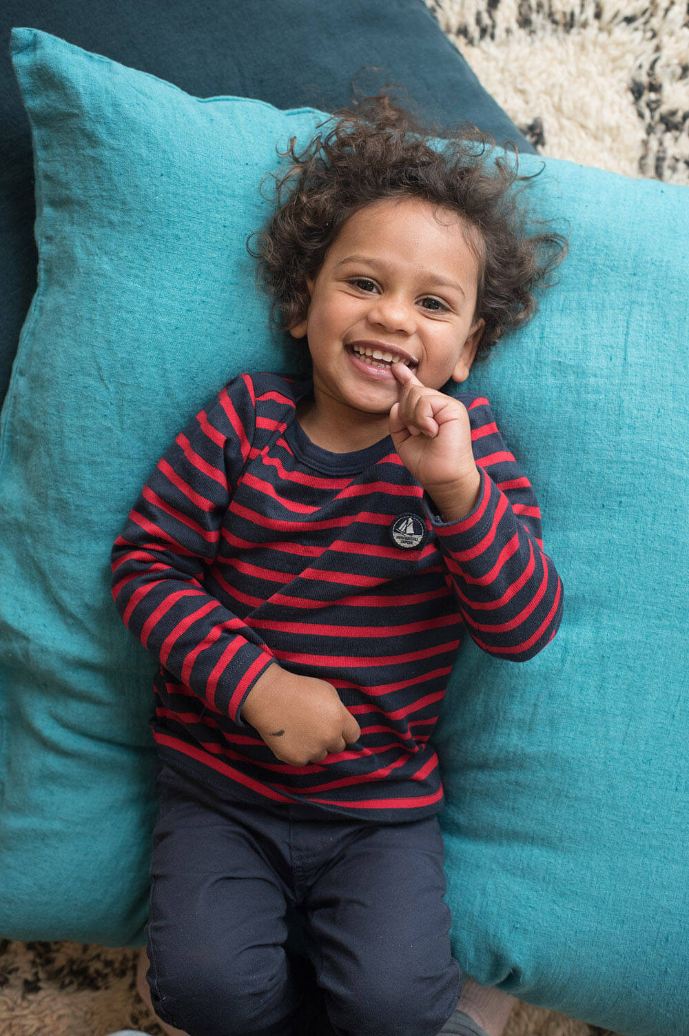 Portrait enfant avec une marinière bleu et rouge.