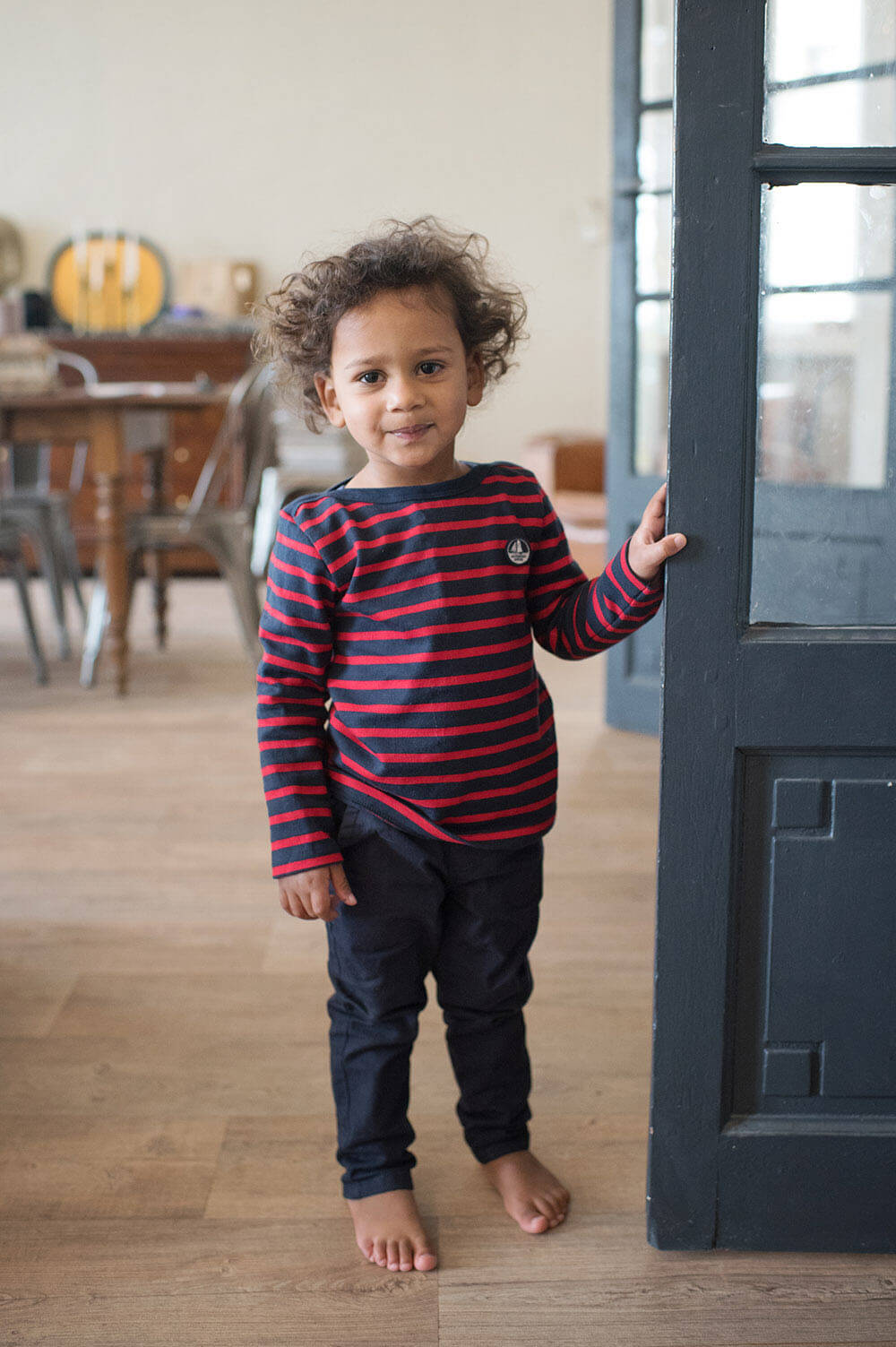 Portrait enfant avec une marinière bleu et rouge.