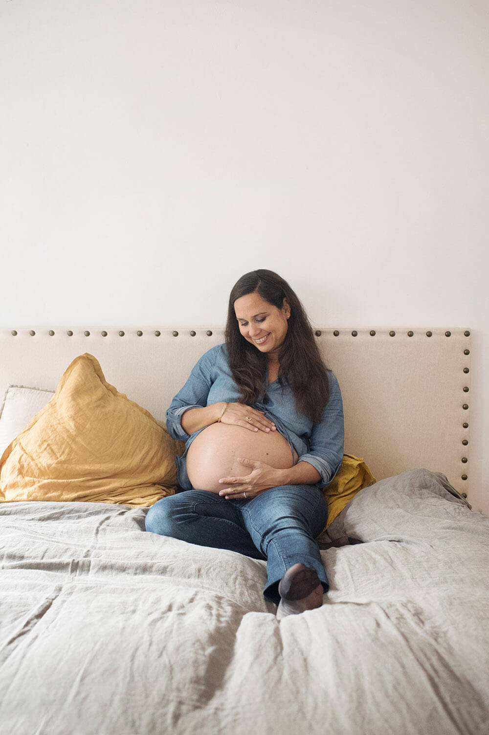 Future maman posant dans sa chambre.