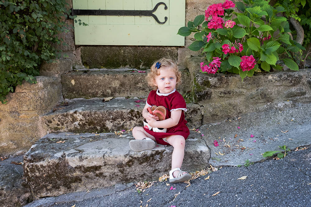 Portrait enfant sur des marches en pierres.