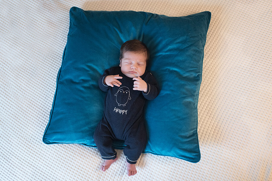 Bébé faisant sa sieste sur coussin bleu électrique.