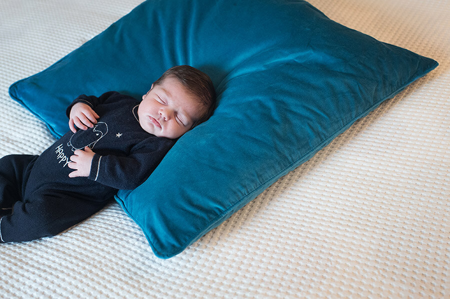 Bébé faisant sa sieste sur coussin bleu électrique.