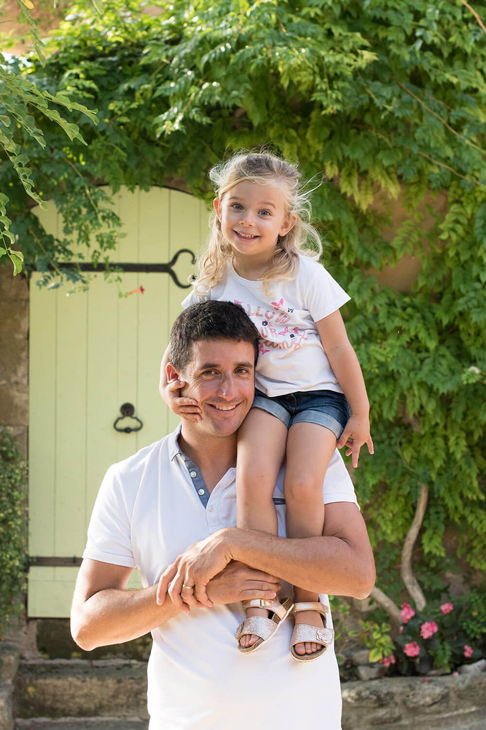 Portrait original d'un papa et de son enfant assise sur de ses une épaules.