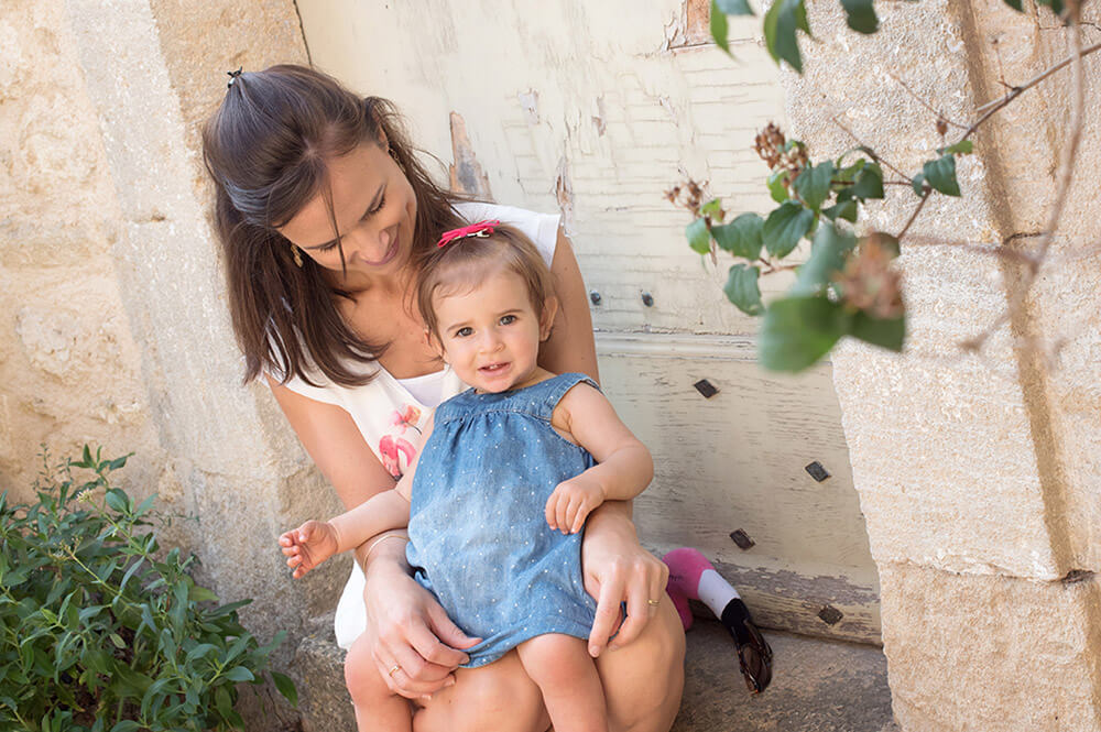 Séance photo famille Luberon. Portrait lifestyle Luberon. Portrait mère-fille assises devant une jolie porte en bois.