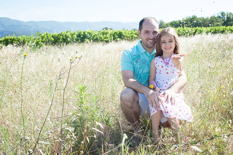 Portrait d'une jeune fille et son papa dans les vignes.