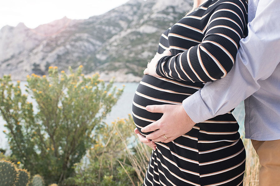 Zoom sur le ventre d'une future maman. Photo faite devant la mer.