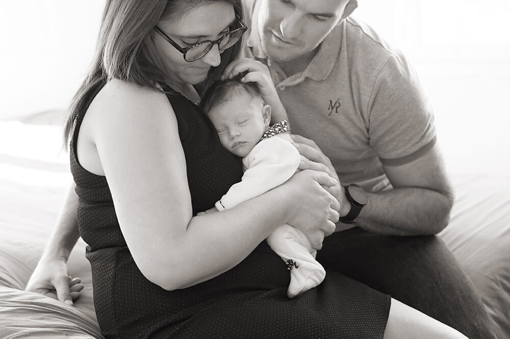 Portrait de jeunes parents avec son nouveau-né. portrait serré en noir et blanc.