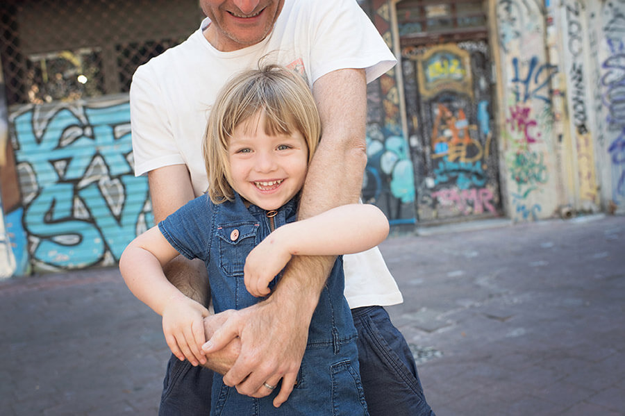 Sourire d'enfant dans les bras de son père.