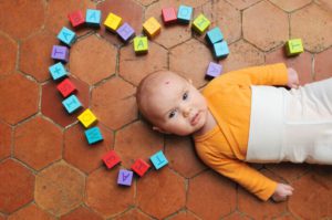 Portrait d'un bébé avec ses cubes en bois colorés.