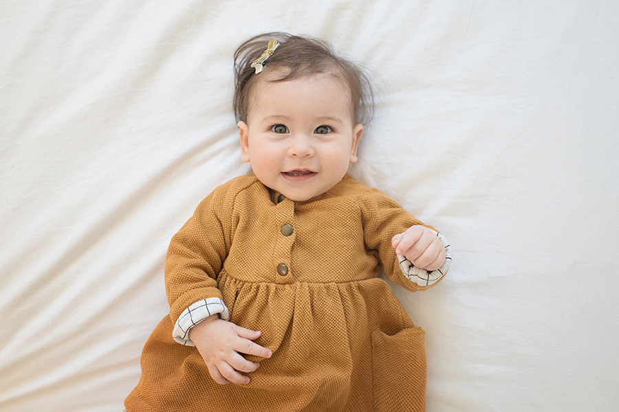 Portrait de bébé avec une jolie robe caramel.
