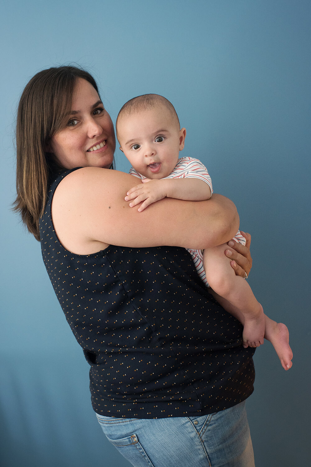 Portrait de bébé et sa maman sur un fond bleu.