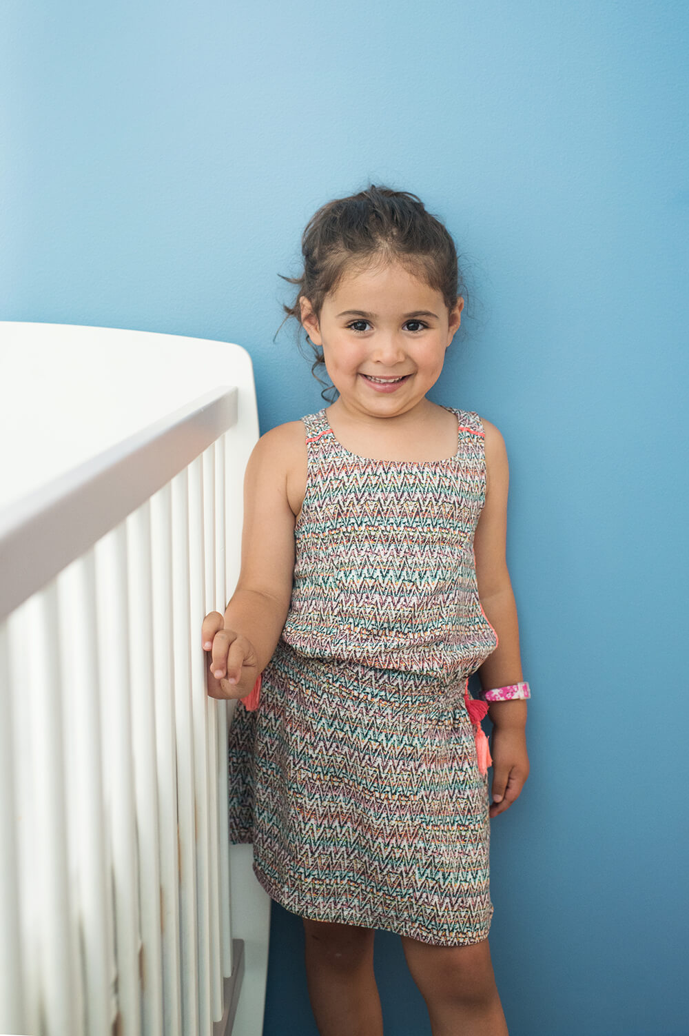 Portrait d'une petite fille sur fond bleu.