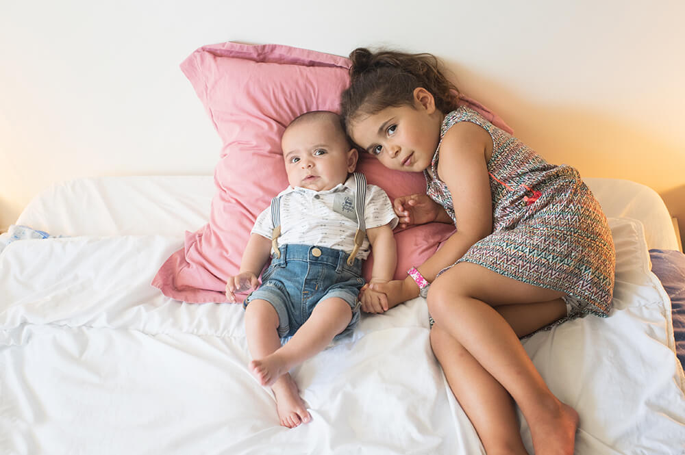 Portrait fratrie naissance sur le lit de parents.