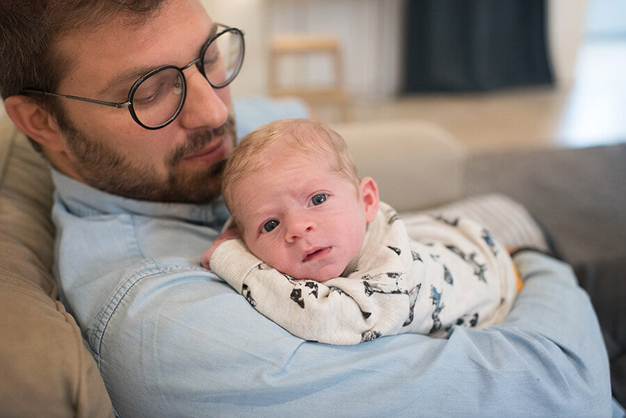 Portrait d'un nourrisson dans les bras de son papa.