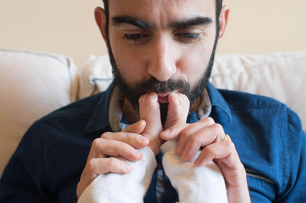 Papa entrain d'embrasser les pieds de son tout-petit.