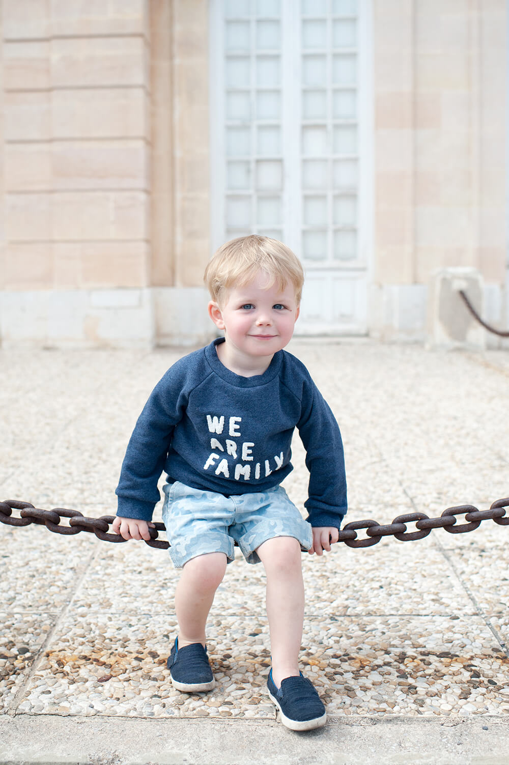 Blondinet jouant à se balancer sur une chaine.