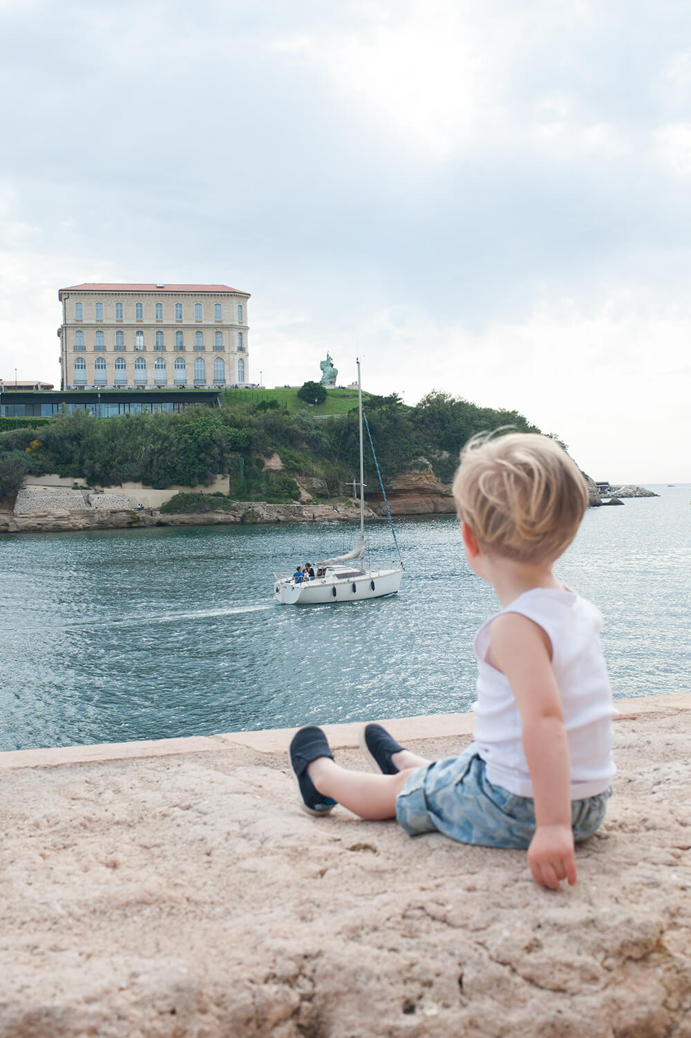 Garçonnet regardant les bateaux passés.