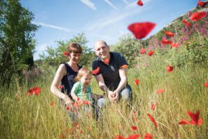 Séance photo famille. En famille dans un champ de coquelicots.