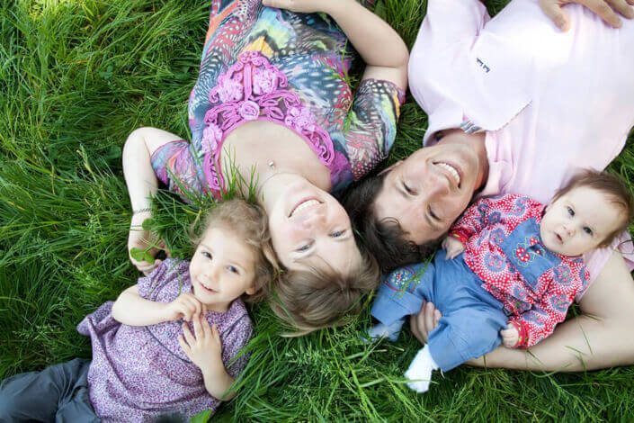Portrait de famille allongé dans l'herbe.