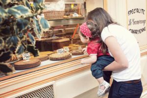 Portrait enfant devant une vitrine de pâtisseries.