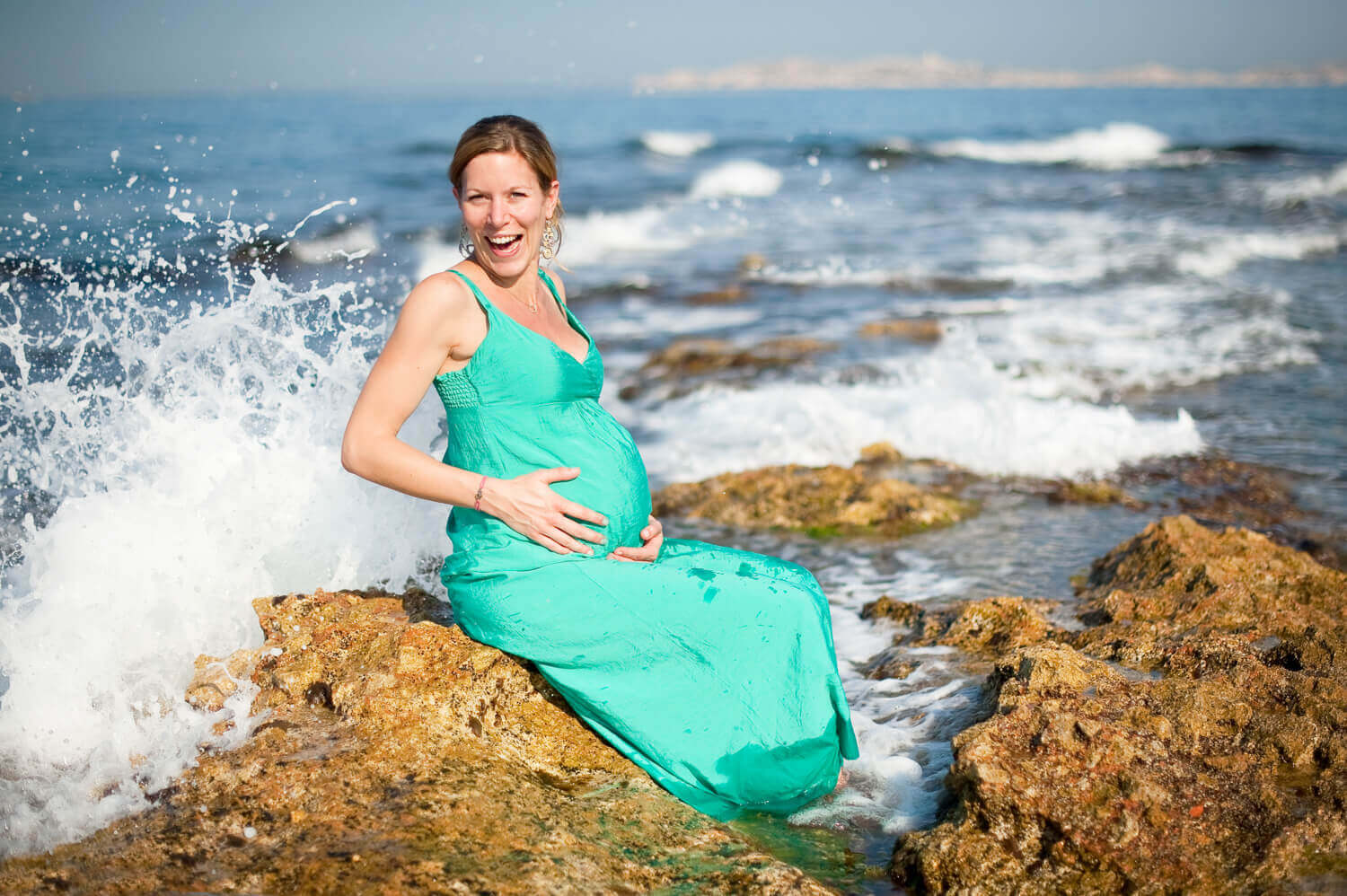 Séance photo grossesse Marseille. Portrait d'une femme enceinte dans la mer.
